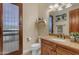 Bathroom with wood vanity, granite countertop, and a decorative mirror and shelf at 2998 E Waterman Way, Gilbert, AZ 85297