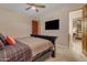 Comfortable bedroom features a ceiling fan, TV, and an adjacent doorway to another room at 2998 E Waterman Way, Gilbert, AZ 85297