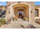 Beautiful arched entryway with stone accents, wooden door, and potted flowers at 2998 E Waterman Way, Gilbert, AZ 85297