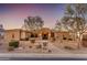 Inviting home featuring stone accents, desert landscaping, and an illuminated entryway at dusk at 2998 E Waterman Way, Gilbert, AZ 85297