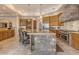 Gourmet kitchen with large island, stone accents, stainless steel appliances, and bar seating at 2998 E Waterman Way, Gilbert, AZ 85297