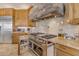 A gourmet kitchen features stainless steel appliances, granite counters, and custom cabinetry at 2998 E Waterman Way, Gilbert, AZ 85297