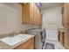 Well-equipped laundry room features updated appliances and ample cabinetry for storage and organization at 2998 E Waterman Way, Gilbert, AZ 85297