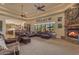 Spacious living room with stone fireplace, large windows, and views of the outdoor area at 2998 E Waterman Way, Gilbert, AZ 85297