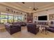 Bright living room featuring a fireplace, large windows, leather furniture, and neutral carpet at 2998 E Waterman Way, Gilbert, AZ 85297