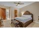 A cozy main bedroom, featuring a decorative bed, a ceiling fan, and ensuite access to a full bathroom at 2998 E Waterman Way, Gilbert, AZ 85297