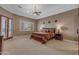 Large bedroom with a tray ceiling, ceiling fan, and access to the outdoors at 2998 E Waterman Way, Gilbert, AZ 85297