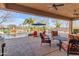 Covered patio with outdoor seating overlooking the pool, waterfall feature, and well-maintained landscaping at 2998 E Waterman Way, Gilbert, AZ 85297