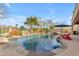 Backyard pool with palm trees, waterfall feature, sun-bathing lounge chairs, and patio at 2998 E Waterman Way, Gilbert, AZ 85297