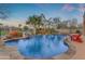 Serene pool area with rock features, palm trees, and desert landscaping with lounge seating at 2998 E Waterman Way, Gilbert, AZ 85297