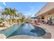 Large backyard pool with water feature, manicured landscaping, patio and outdoor seating area at 2998 E Waterman Way, Gilbert, AZ 85297
