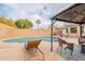Backyard with a refreshing pool, covered seating, lounge chairs, and lush greenery at 316 W Kelton Ln, Phoenix, AZ 85023