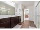 Bathroom boasts double sinks, wood-look floors, and a glass door shower at 37295 W Cannataro Ln, Maricopa, AZ 85138