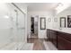 Bathroom with glass shower, wood-look flooring, and access to walk-in closet at 37295 W Cannataro Ln, Maricopa, AZ 85138
