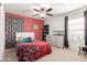 Bedroom with red accent wall, ceiling fan, and neutral carpet at 37295 W Cannataro Ln, Maricopa, AZ 85138