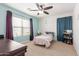 Bedroom with bright blue accent wall, ceiling fan, and natural light at 37295 W Cannataro Ln, Maricopa, AZ 85138