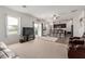 Open-concept living room with neutral carpeting flowing into a modern kitchen at 37295 W Cannataro Ln, Maricopa, AZ 85138