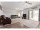 Bright living room with a ceiling fan and sliding glass doors to the backyard at 37295 W Cannataro Ln, Maricopa, AZ 85138