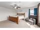 Large main bedroom with a cozy chair, carpet floors, and a ceiling fan at 37295 W Cannataro Ln, Maricopa, AZ 85138