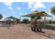 A fun community playground with shade coverings, slides, and climbing equipment at 37295 W Cannataro Ln, Maricopa, AZ 85138