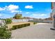 Spacious backyard features a large stone patio, low shrubbery and block fence with grassy area at 40975 N Arbor Ave, San Tan Valley, AZ 85140