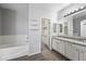 Well-lit bathroom with a large tub and granite counters, leading to a walk-in closet at 40975 N Arbor Ave, San Tan Valley, AZ 85140