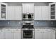 Modern kitchen featuring stainless steel appliances, white cabinets, and a sleek backsplash at 40975 N Arbor Ave, San Tan Valley, AZ 85140