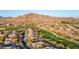 Stunning aerial view showcases luxurious homes nestled along a pristine golf course with mountain views at 42019 N Golf Crest Rd, Anthem, AZ 85086