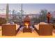 Cozy back patio with fire place feature, seating, and scenic desert views at dusk at 42019 N Golf Crest Rd, Anthem, AZ 85086