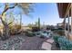 Lush backyard oasis showcasing desert landscaping, a rock waterfall pool, and a tranquil outdoor setting at 42019 N Golf Crest Rd, Anthem, AZ 85086