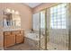 Well-lit bathroom with a glass enclosed shower, tub and double sinks at 42019 N Golf Crest Rd, Anthem, AZ 85086