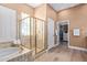 Bright bathroom with a glass enclosed shower, tub, and large walk-in closet at 42019 N Golf Crest Rd, Anthem, AZ 85086