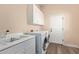 Bright laundry room features updated appliances, a large sink, and ample storage space at 42019 N Golf Crest Rd, Anthem, AZ 85086
