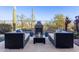 Comfortable patio seating area with a fireplace, potted plants and desert landscaping offering a relaxing outdoor space at 42019 N Golf Crest Rd, Anthem, AZ 85086