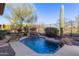 Inviting pool featuring a rock waterfall, surrounded by desert landscaping and a tall saguaro cactus at 42019 N Golf Crest Rd, Anthem, AZ 85086