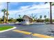 Inviting community entrance with a guardhouse, lush landscaping, and palm trees under a sunny sky at 4800 N 68Th St # 385, Scottsdale, AZ 85251