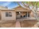 Backyard with covered patio, two chairs, mature trees, and cozy outdoor space is perfect for entertaining at 5002 W Wikieup Ln, Glendale, AZ 85308