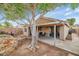 Inviting backyard featuring a covered patio with seating and mature landscaping, perfect for outdoor relaxation at 5002 W Wikieup Ln, Glendale, AZ 85308