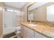 This bathroom includes a vanity with a granite countertop and a shower and tub combo at 5002 W Wikieup Ln, Glendale, AZ 85308