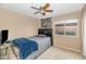 Neutral bedroom features a ceiling fan, window, and dark bed frame at 5002 W Wikieup Ln, Glendale, AZ 85308