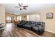 Spacious living room featuring modern flooring, a ceiling fan and a large leather couch at 5002 W Wikieup Ln, Glendale, AZ 85308