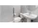Cozy bathroom featuring a pedestal sink and toilet with accessibility bars at 504 E Quentin Ln, San Tan Valley, AZ 85140