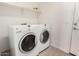 Functional laundry room with a white washer and dryer set and overhead shelving for storage solutions at 504 E Quentin Ln, San Tan Valley, AZ 85140