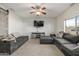 Comfortable living room with a large gray sectional, ceiling fan, and entertainment center at 504 E Quentin Ln, San Tan Valley, AZ 85140