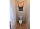 A cozy half-bathroom showcases tiled floors, complemented by a floral valance over the window for a touch of charm at 6016 W Gambit Trl, Phoenix, AZ 85083