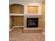 Close up of the living room fireplace with decorative tile and built-in alcoves for storage at 6016 W Gambit Trl, Phoenix, AZ 85083