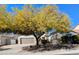 A picturesque single-story home is accentuated by a large shade tree and a well-manicured lawn at 6016 W Gambit Trl, Phoenix, AZ 85083