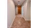 A home's hallway features light walls, tile floors, and a wooden front door at 6016 W Gambit Trl, Phoenix, AZ 85083