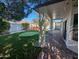 Covered patio overlooking a well-manicured backyard with a putting green and hot tub at 6016 W Gambit Trl, Phoenix, AZ 85083