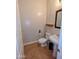 A charming powder room with tile floors, a pedestal sink, and a decorative mirror at 6016 W Gambit Trl, Phoenix, AZ 85083